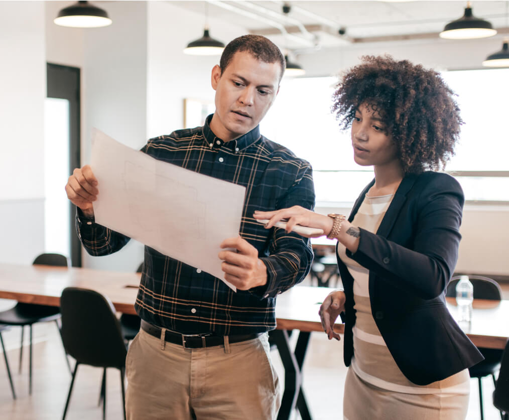 A man and woman standing and discussing a plan